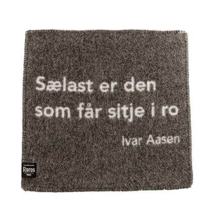 Sitjeunderlag i ull, med sitat av Ivar Aasen